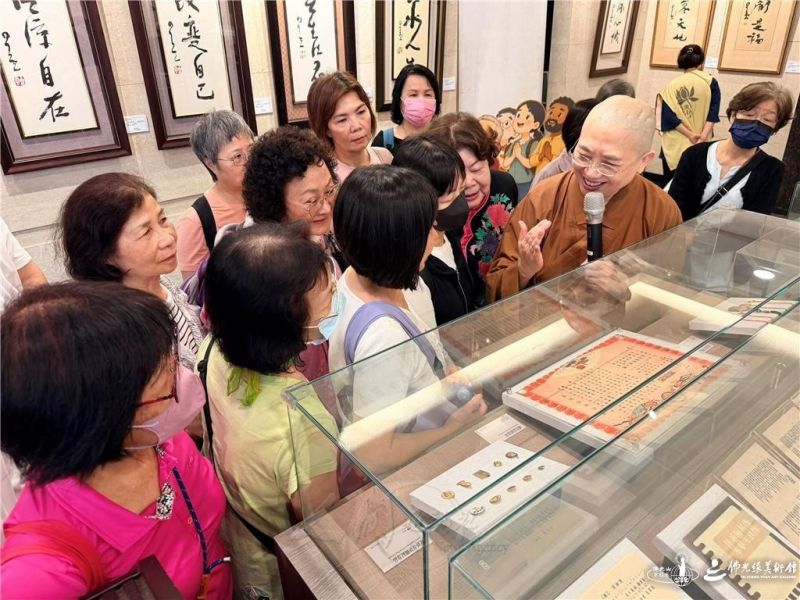 圖說:妙勤法師在導覽時,解說當年佛化婚禮的結婚證書印有彌勒佛圖像,令人讚嘆星雲大師的創意無限。 人間社記者傅娟娟攝 20260621-new-006