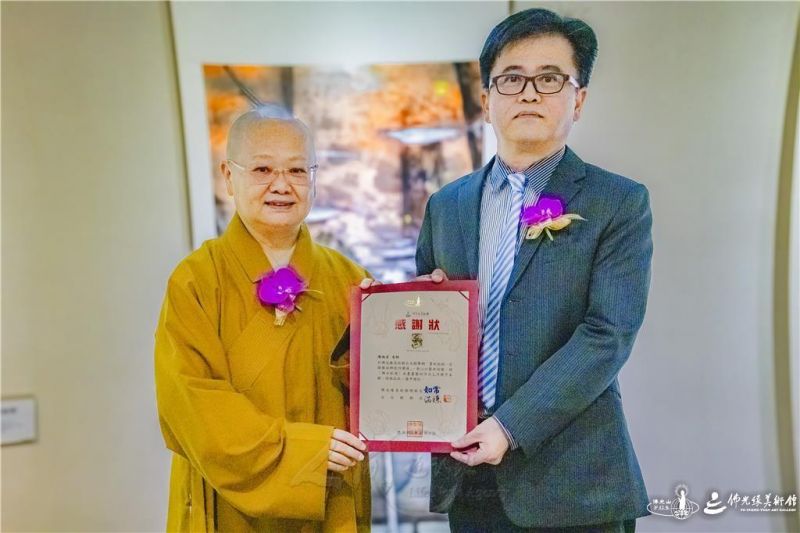 圖說:佛光緣美術館台北館館長暨佛光山台北道場住持滿謙法師(左)頒贈感謝狀,感謝國立台灣藝術大學書畫藝術學系教授陳炳宏(右)帶領師生團隊舉辦「墨旅微探」聯展,並致贈作品。 人間社記者陳保吉攝 20261006-taipei-002